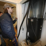
              John Paul, front, and David Valenzuela work to install a heat pump in an 80-year-old rowhouse Friday, Jan. 20, 2023, in northwest Denver. (AP Photo/David Zalubowski)
            