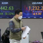 
              A currency trader passes by monitors near the screens showing the Korea Composite Stock Price Index (KOSPI), left, and the foreign exchange rate between U.S. dollar and South Korean won at the foreign exchange dealing room of the KEB Hana Bank headquarters in Seoul, South Korea, Tuesday, Jan. 31, 2023. Asian shares mostly fell in muted trading Tuesday as investors awaited decisions on interest rates and earnings reports from around the world. (AP Photo/Ahn Young-joon)
            