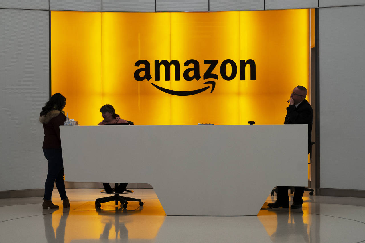 FILE - In this Feb. 14, 2019 file photo, people stand in the lobby for Amazon offices in New York. ...