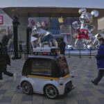 
              A police robot vehicle patrols past masked visitors at an outdoor shopping center in Beijing, Thursday, Jan. 5, 2023. As COVID-19 rips through China, other countries and the WHO are calling on its government to share more comprehensive data on the outbreak, with some even saying many of the numbers it is reporting are meaningless. (AP Photo/Andy Wong)
            