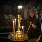 
              A girl lights a candle before the start of the Orthodox Christmas in the St. Michael's Monastery of Kyiv, Ukraine, Friday, Jan. 6, 2023. Russian President Vladimir Putin on Thursday ordered Moscow's armed forces to observe a 36-hour cease-fire in Ukraine this weekend for the Russian Orthodox Christmas holiday, but Ukrainian President Volodymyr Zelenskyy questioned the Kremlin's intentions. (AP Photo/Bela Szandelszky)
            