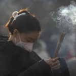 
              A visitor burns incense as she prays on the first day of the Lunar New Year holiday at the Lama Temple in Beijing, Sunday, Jan. 22, 2023. People across China rang in the Lunar New Year on Sunday with large family gatherings and crowds visiting temples after the government lifted its strict "zero-COVID" policy, marking the biggest festive celebration since the pandemic began three years ago. (AP Photo/Mark Schiefelbein)
            
