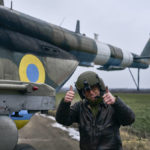 
              A pilot shows thumbs up before a combat flight standing near his helicopter at a Ukrainian military air base close to the frontline in the Kherson region, Ukraine, Sunday, Jan. 8, 2023. (AP Photo/LIBKOS)
            