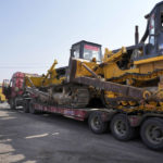 
              A trailer loaded with bulldozers is stopped at a checkpoint along a road leading to the site of a collapsed open pit mine in Alxa League in northern China's Inner Mongolia Autonomous Region, Thursday, Feb. 23, 2023. An open pit mine collapsed in China's northern Inner Mongolia region on Wednesday, killing multiple people and leaving dozens more missing, state media reported. (AP Photo/Ng Han Guan)
            
