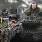 
              German Defense Minister Boris Pistorius, right, sits on a Leopard 2 tank at the Bundeswehr tank battalion 203 at the Field Marshal Rommel Barracks in Augustdorf, Germany, Wednesday, Feb. 1, 2023. After the government's decision to deliver fourteen Leopard 2 tanks to Ukraine, the capabilities of the Leopard 2A6 main battle tank are shown at a presentation in Augustdorf. (AP Photo/Martin Meissner)
            
