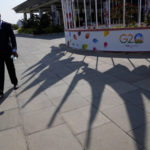 
              A security official walks past the shadows of the flags of participating countries displayed at the venue of G-20 financial conclave on the outskirts of Bengaluru, India, Wednesday, Feb. 22, 2023. Top financial leaders from the Group of 20 leading economies are gathering in the south Indian technology hub of Bengaluru to tackle challenges to global growth and stability. India is hosting the G-20 financial conclave for the first time in 20 years. (AP Photo/Aijaz Rahi)
            