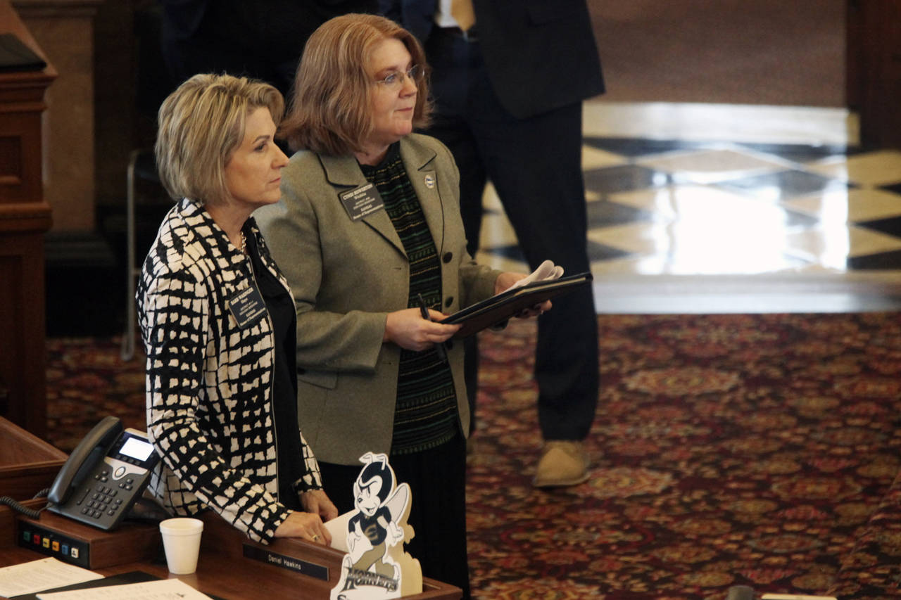 Kansas state Reps. Barb Wasinger, R-Hays, left, and Cindi Howerton, right, R-Wichita, follow a deba...