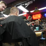 
              Hairstylist Stanislav Shenkevich, 29, from St. Petersburg gives a customer a haircut at a barbershop in Belgrade, Serbia, Monday, Jan. 16, 2023. A friendly, fellow-Slavic nation, Serbia has welcomed the fleeing Russians who need visas to travel to much richer Western European states. But in Serbia, they have not escaped the long reach of Putin's hardline regime influence. (AP Photo/Darko Vojinovic)
            