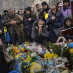
              Nadia, center, prays at the grave of her son Oleg Kunynets, a Ukrainian military serviceman who was killed in the east of the country, during his funeral in Lviv, Ukraine, Tuesday, Feb 7, 2023. (AP Photo/Emilio Morenatti)
            
