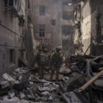 
              FILE - Ukrainian servicemen walk among debris of damaged buildings after a Russian attack in Kharkiv, Ukraine, Saturday, April 16, 2022.  As milestones go, the first anniversary of Russia's invasion of Ukraine is both grim and vexing. It marks a full year of killing, destruction, loss and pain felt even beyond the borders of Russia and Ukraine. (AP Photo/Felipe Dana, File)
            