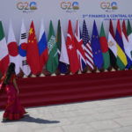 
              A delegate walks past a display of flags of participating countries at the venue of G-20 financial conclave on the outskirts of Bengaluru, India, Wednesday, Feb. 22, 2023. Top financial leaders from the Group of 20 leading economies are gathering in the south Indian technology hub of Bengaluru to tackle challenges to global growth and stability. India is hosting the G-20 financial conclave for the first time in 20 years. (AP Photo/Aijaz Rahi)
            