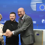 
              FILE - From left, European Commission President Ursula von der Leyen, Ukraine's President Volodymyr Zelenskyy, center, and European Council President Charles Michel join hands after addressing a media conference at an EU summit in Brussels on Thursday, Feb. 9, 2023.   A year ago, with Russian forces bearing down on Ukraine’s capital, Western leaders feared for the life of President Volodymyr Zelenskyy and the U.S. offered him an escape route. Zelenskyy declined, declaring his intent to stay and defend Ukraine’s independence. (AP Photo/Olivier Matthys, File)
            