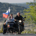 
              Russian President Vladimir Putin, left, drives a motorbike decorated with a Russian national flag, with Crimean leader Sergei Aksenov, in sidecar, and Sevastopol Gov. Mikhail Razvozhaev, behind, during the Babylon's Shadow bike show camp in Sevastopol, Crimea, on Saturday, Aug. 10, 2019.  Putin sent forces into Ukraine on Feb. 24, 2022, and appears determined to prevail -- ruthlessly and at all costs. (Alexei Druzhinin, Sputnik, Kremlin Pool Photo via AP)
            