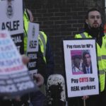 
              Rail workers hold up a sign with pictures of a television puppet character Roland Rat, left, and British Prime Minister Rishi Sunak during a strike outside Euston station in London, Wednesday, Feb. 1, 2023. Thousands of schools in the U.K. are closing some or all of their classrooms, train services will be paralyzed and delays are expected at airports Wednesday in what’s shaping up to be the biggest day of industrial action Britain has seen in more than a decade, as unions step up pressure on the government to demand better pay amid a cost-of-living crisis. (AP Photo/Kin Cheung)
            