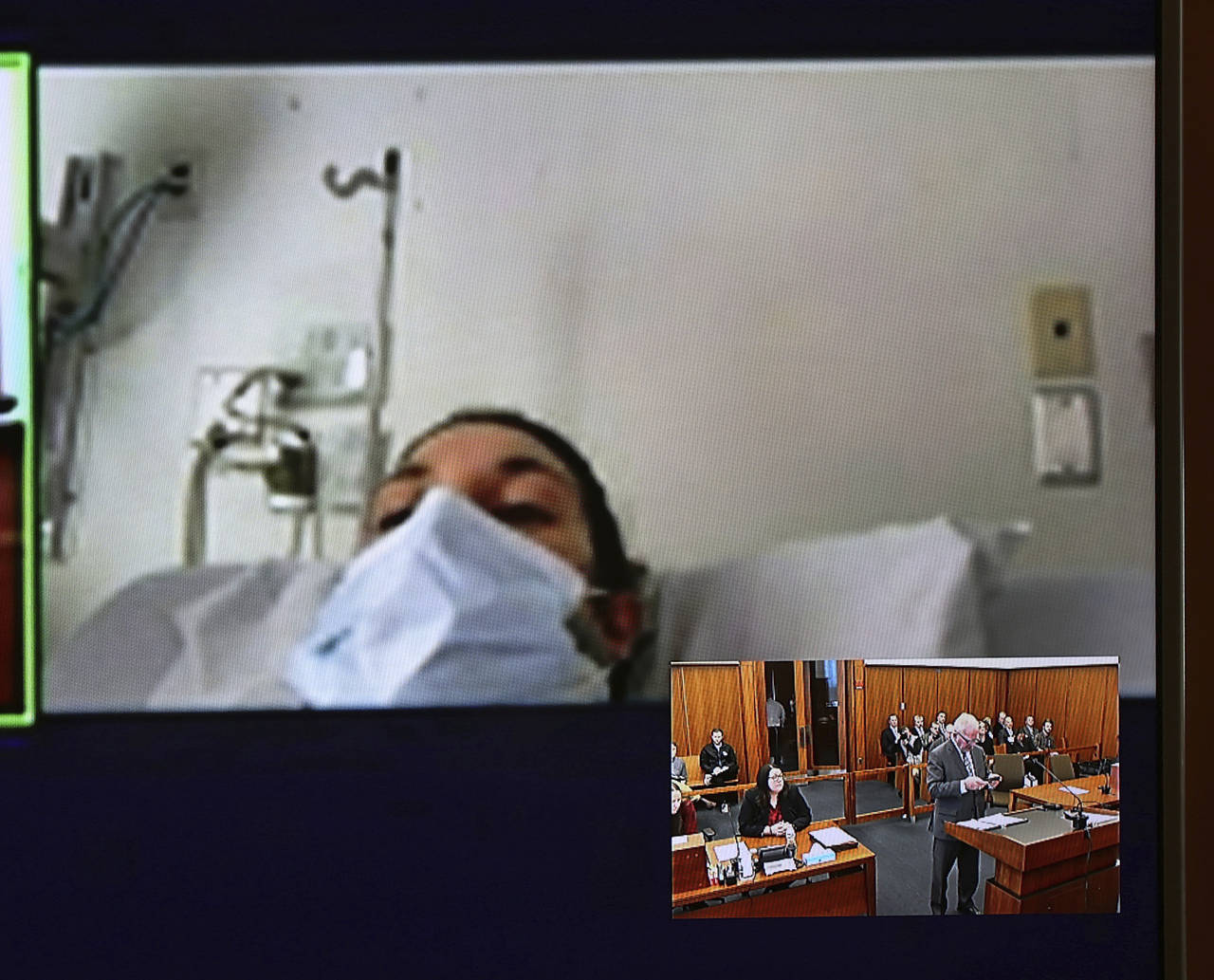 In this video screen image, Lindsay Clancy with a surgical mask over her face in a hospital appears...