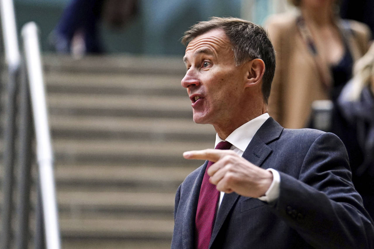 British Chancellor Jeremy Hunt gestures before speaking to the media at Victoria Place Shopping Cen...