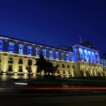 
              Vehicles drive past the Portuguese Parliament lit with the Ukrainian flag colors to mark the one-year anniversary of the invasion of Ukraine, in Lisbon, as night falls Thursday, Feb. 23, 2023. (AP Photo/Armando Franca)
            