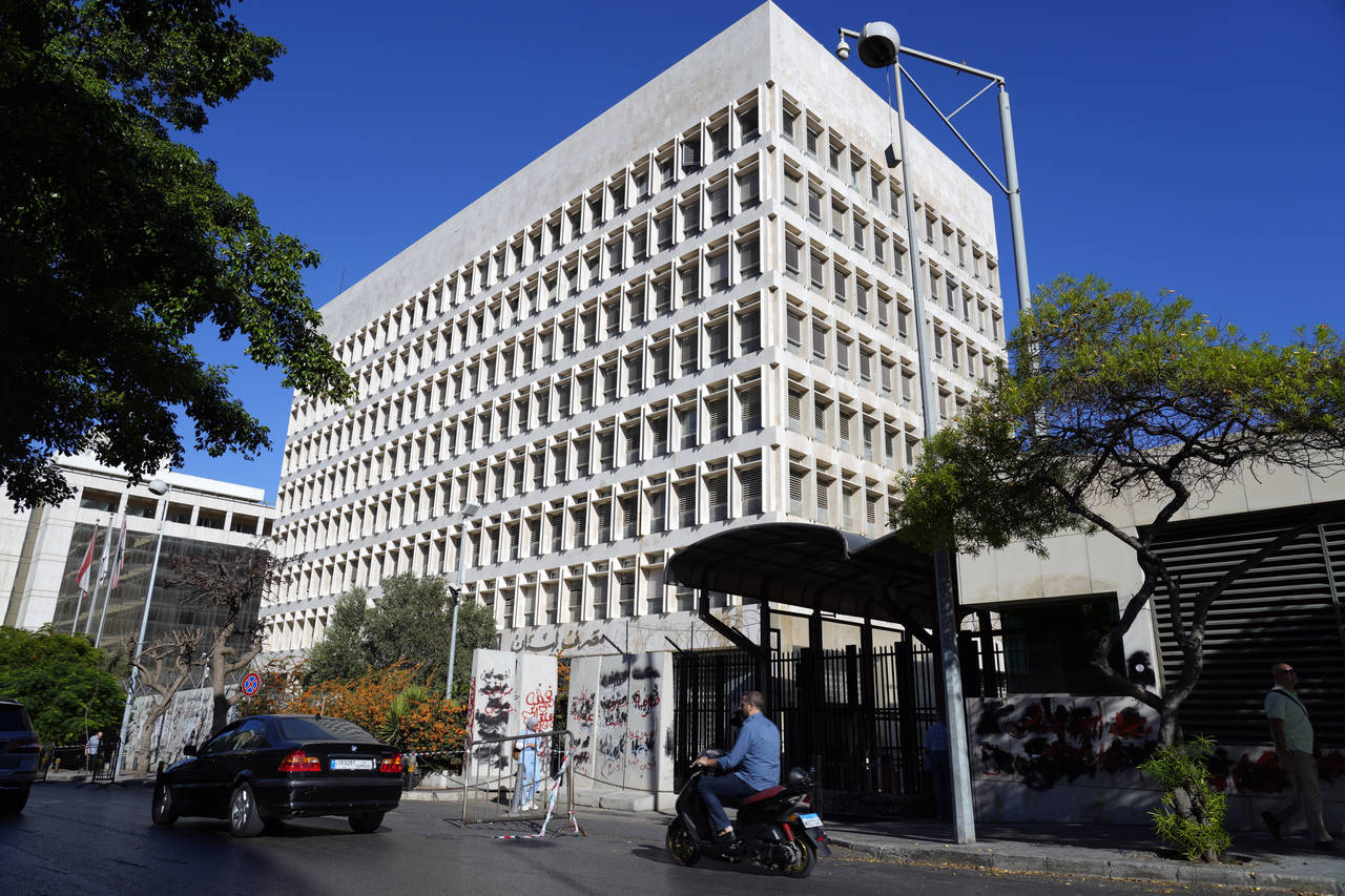 FILE - People pass by the Lebanese Central Bank, in Beirut, Lebanon, Monday, Sept. 26, 2022. Three ...