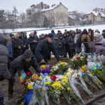 
              Relatives place flowers at the grave of Yevhen Zapotichnyi, a Ukrainian military servicemen who were killed in the east of the country, during his funeral in Lviv, Ukraine, Tuesday, Feb 7, 2023. (AP Photo/Emilio Morenatti)
            