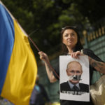 
              Ukrainians who live in Brazil protest outside Russia's consulate on the one-year anniversary of Russia's invasion of Ukraine, in Sao Paulo, Brazil, Friday, Feb. 24, 2023. The sign shows Russian President Vladimir Putin, alluding him to Germany's late dictator Adolf Hitler. (AP Photo/Andre Penner)
            