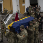 
              Soldiers carry the coffin of Eduard Strauss, a Ukrainian serviceman who died in combat on Jan. 17 in Bakhmut, during a farewell ceremony in Kyiv, Ukraine, Monday, Feb. 6, 2023. (AP Photo/Daniel Cole)
            