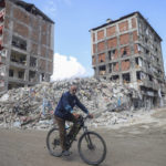 
              A man rides a bicycle past destroyed buildings in Antakya, southeastern Turkey, Tuesday, Feb. 21, 2023. The death toll in Turkey and Syria rose to eight in a new and powerful earthquake that struck two weeks after a devastating temblor killed nearly 45,000 people, authorities and media said Tuesday. (AP Photo/Unal Cam)
            