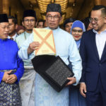 
              Malaysia's Prime Minister and Finance Minister Anwar Ibrahim, center, poses with a briefcase containing his 2023 budget speech as he leaves the Finance Ministry building for the Parliament in Putrajaya, Malaysia, Friday, Feb. 24, 2023. (AP Photo)
            