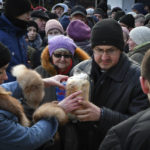 
              People receive bread at a humanitarian aid distribution spot in Zaporizhzhya, Ukraine, Monday, Feb. 6, 2023. (AP Photo/Andriy Andriyenko)
            