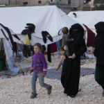 
              FILE - Women and children who lost their homes walk in among tents at a camp in Atareb, Syria, Sunday, Feb. 12, 2023. Women in particular have shouldered the responsibility of keeping shattered families together during the past 12 years of civil war.  The massive earthquake that hit last week is the latest in a litany of hardships for Syrian women, many of whom have been left dependent on aid and alone responsible for their families' well-being. (AP Photo/Hussein Malla, File)
            