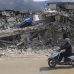 
              A man rides a motorbike past destroyed buildings in Antakya, southeastern Turkey, Tuesday, Feb. 21, 2023. The death toll in Turkey and Syria rose to eight in a new and powerful earthquake that struck two weeks after a devastating temblor killed nearly 45,000 people, authorities and media said Tuesday. (AP Photo/Unal Cam)
            