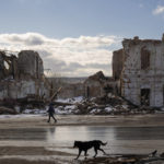 
              FILE - A woman walks by a building destroyed by a Russian strike in Kupiansk, Ukraine, Monday, Feb. 20, 2023. Grueling artillery battles have stepped up in recent weeks in the vicinity of Kupiansk, a strategic town on the eastern edge of Kharkiv province by the banks of the Oskil River as Russian attacks intensifying in a push to capture the entire industrial heartland known as the Donbas, which includes the Donetsk and the Luhansk provinces. (AP Photo/Vadim Ghirda, File)
            