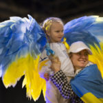 
              Four-year-old Stefania Lavrenko wears angel wings in the colours of the Ukraine flag as she poses with other refugees during a gathering at a convention center in Utrecht, Netherlands, Friday, Feb. 24, 2023, to mark the anniversary of the Russian invasion of the Ukraine one year ago. (AP Photo/Peter Dejong)
            