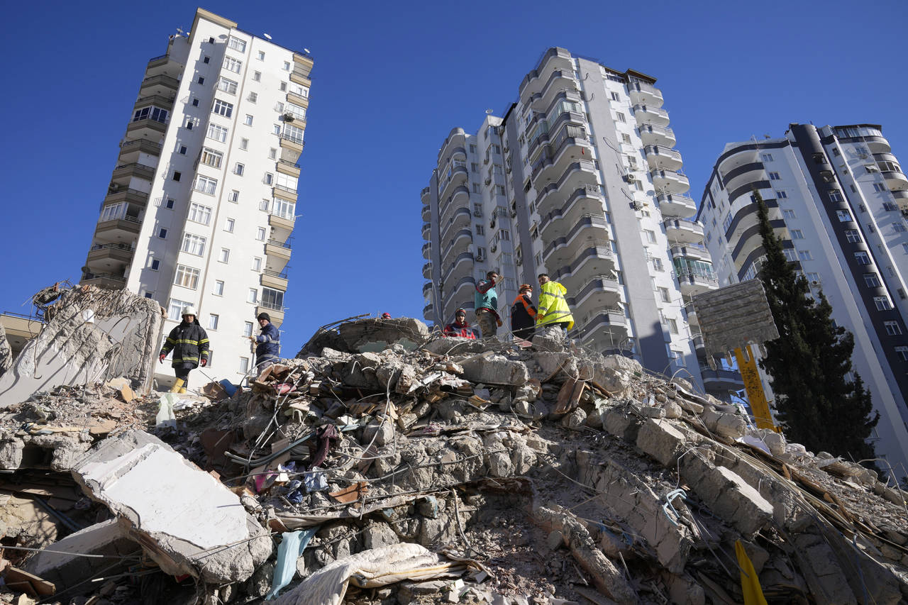 FILE - Emergency teams search for people in the rubble of a destroyed building in Adana, southern T...
