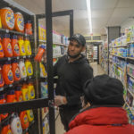 
              Leo Pichardo, left, a store associate at Gristedes supermarket, retrieves a container of Tide laundry soap from a locked cabinet, Tuesday Jan. 31, 2023, at the store in New York. Increasingly, retailers are locking up more products or increasing the number of security guards at their stores to curtail theft. (AP Photo/Bebeto Matthews)
            