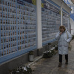 
              Women walk by the "Memory wall of fallen defenders of Ukraine in Russia-Ukrainian war" in downtown Kyiv, Ukraine, Tuesday, Feb. 7, 2023. (AP Photo/Daniel Cole)
            