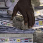 
              An electoral officer uses a stone to keep ballot papers from being blown away, as counting takes place at a polling station in Lagos, Nigeria Saturday, Feb. 25, 2023. Voters in Africa's most populous nation are heading to the polls Saturday to choose a new president, following the second and final term of incumbent Muhammadu Buhari. (AP Photo/Ben Curtis)
            