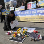 
              A protester places a flower to pay tribute to children killed in Russia's war against Ukraine during a rally to mark the one-year anniversary of Russia's invasion of Ukraine, near the Russian Embassy in Seoul, South Korea, Friday, Feb. 24, 2023. (AP Photo/Ahn Young-joon)
            