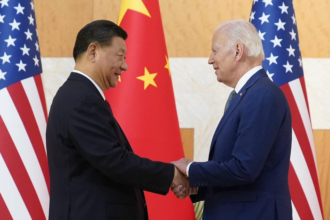 FILE - U.S. President Joe Biden, right, and Chinese President Xi Jinping shake hands before their m...