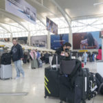 
              Passengers sit with their luggage in Terminal 1 at John F. Kennedy International Airport in New York, Friday, Feb. 17, 2023. A power outage in the terminal has stretched into a second day. The outage has stranded passengers and forced flights to be canceled or diverted to other airports. (AP Photo/Seth Wenig)
            