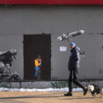 
              A man passes by an artwork by famous street artist TvBoy created on an older graffiti depicting a Ukrainian soldier firing an anti-tank missile. Writing on the missile reads: "The goal is one”, in Kyiv, Ukraine, Wednesday, Feb. 1, 2023. (AP Photo/Efrem Lukatsky)
            