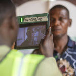 
              A man has his photo taken by an electoral worker before voting during the presidential elections in Agulu, Nigeria, Saturday, Feb. 25, 2023. Voters in Africa's most populous nation are heading to the polls Saturday to choose a new president, following the second and final term of incumbent Muhammadu Buhari. (AP Photo/Mosa'ab Elshamy)
            
