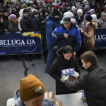 
              People receive bread and milk as a humanitarian aid at a distribution spot in Zaporizhzhya, Ukraine, Monday, Feb. 6, 2023. (AP Photo/Andriy Andriyenko)
            