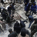 
              Syrian Civil Defense workers and security forces search through the wreckage of collapsed buildings, in Aleppo, Syria, Monday, Feb. 6, 2023. A powerful earthquake rocked wide swaths of Turkey and neighboring Syria on Monday, toppling hundreds of buildings and killing and injuring thousands of people. (AP Photo/Omar Sanadiki)
            