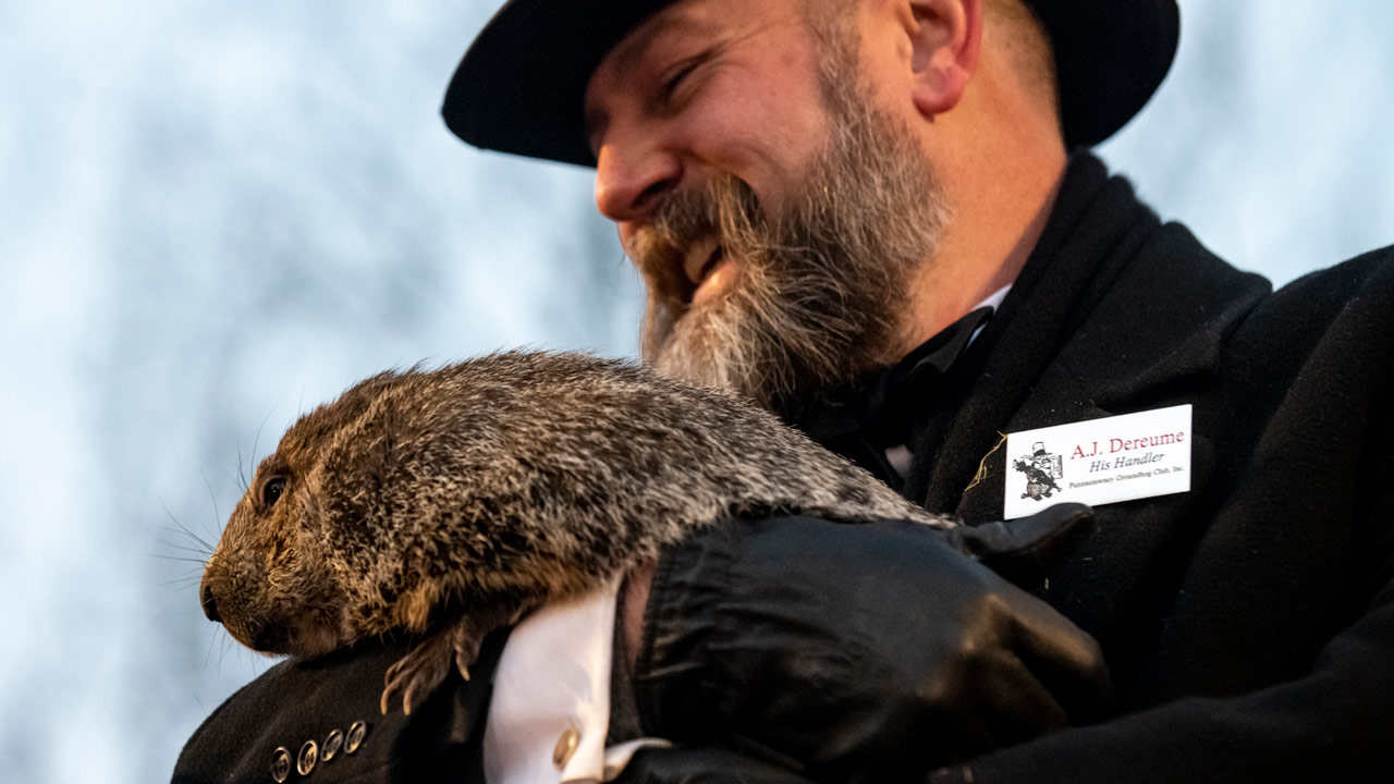 Groundhog handler A.J. Dereume holds Punxsutawney Phil, who saw his shadow, predicting a late sprin...