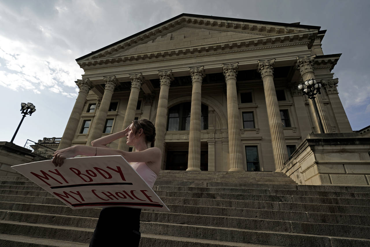 FILE - Zoe Schell, from Topeka, Kan., stands on the steps of the Kansas Statehouse during a rally t...