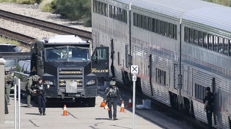 A Tucson Police Department SWAT truck is parked near the last two cars of an Amtrak train in downto...