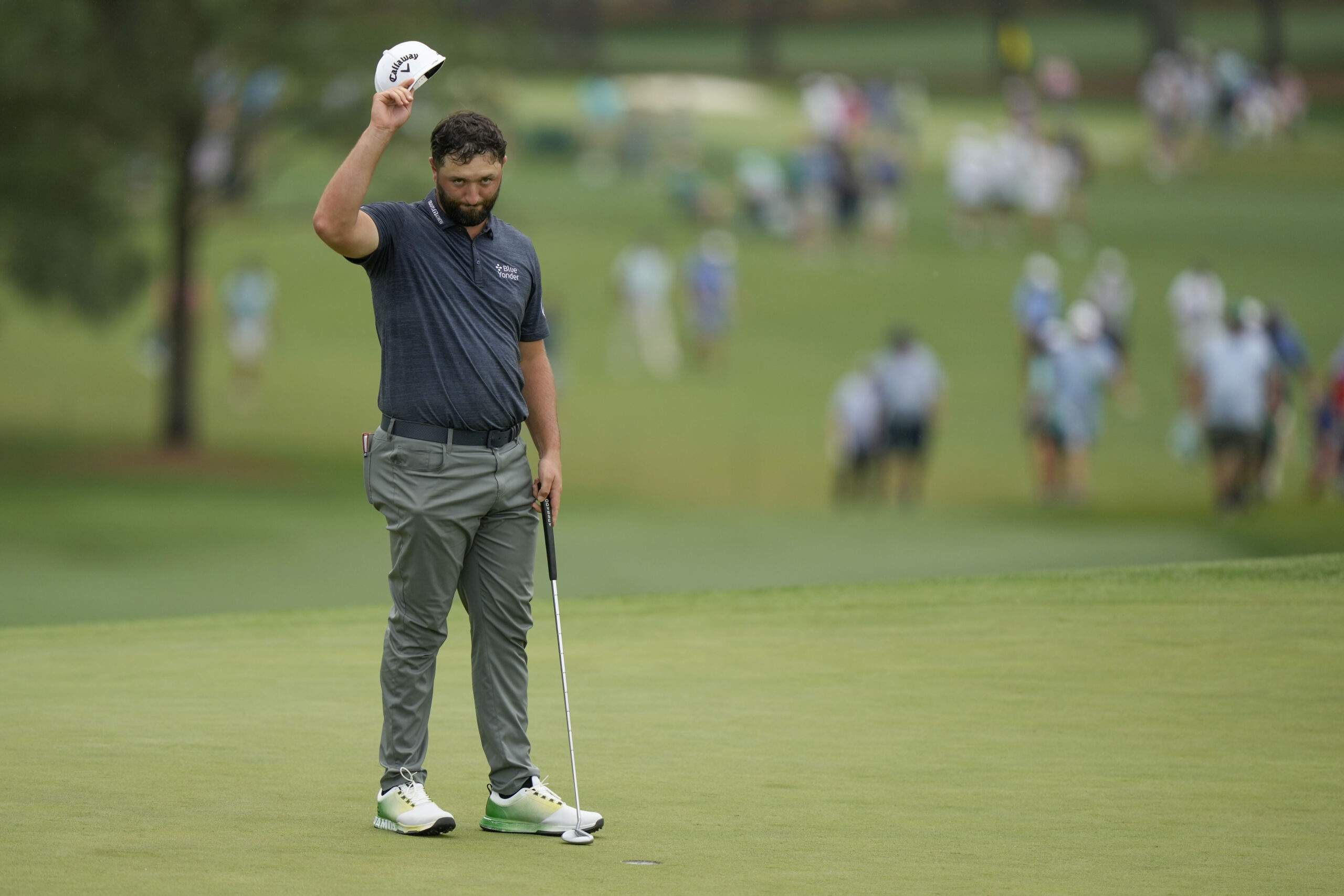 Jon Rahm, of Spain, waves after his putt on the 18th hole during the first round of the Masters gol...