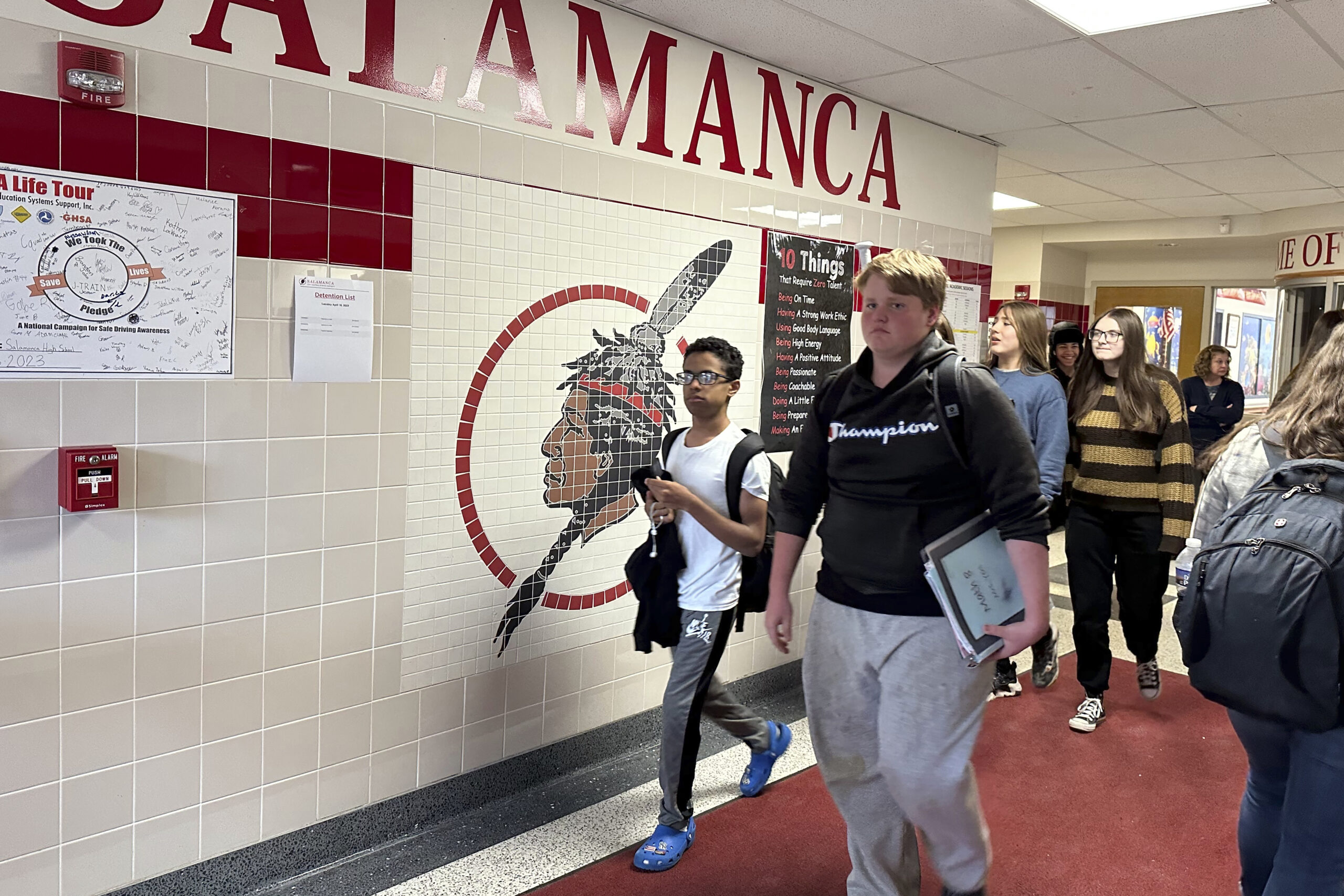 Students walk past a logo that is tiled into the wall at Salamanca High School in Salamanca, N.Y., ...