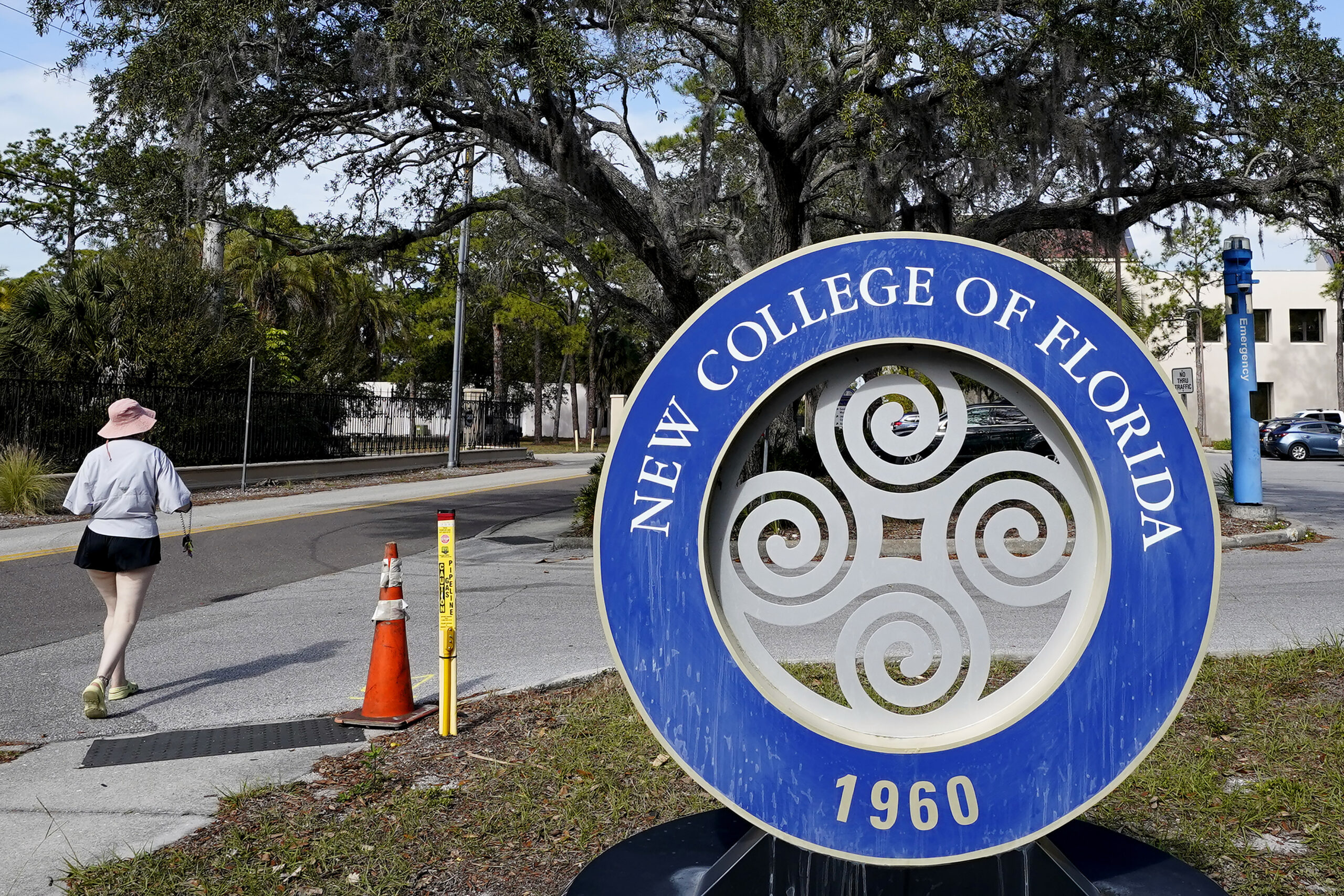 FILE - A student makes her way past the sign at New College of Florida, Jan. 20, 2023, in Sarasota,...