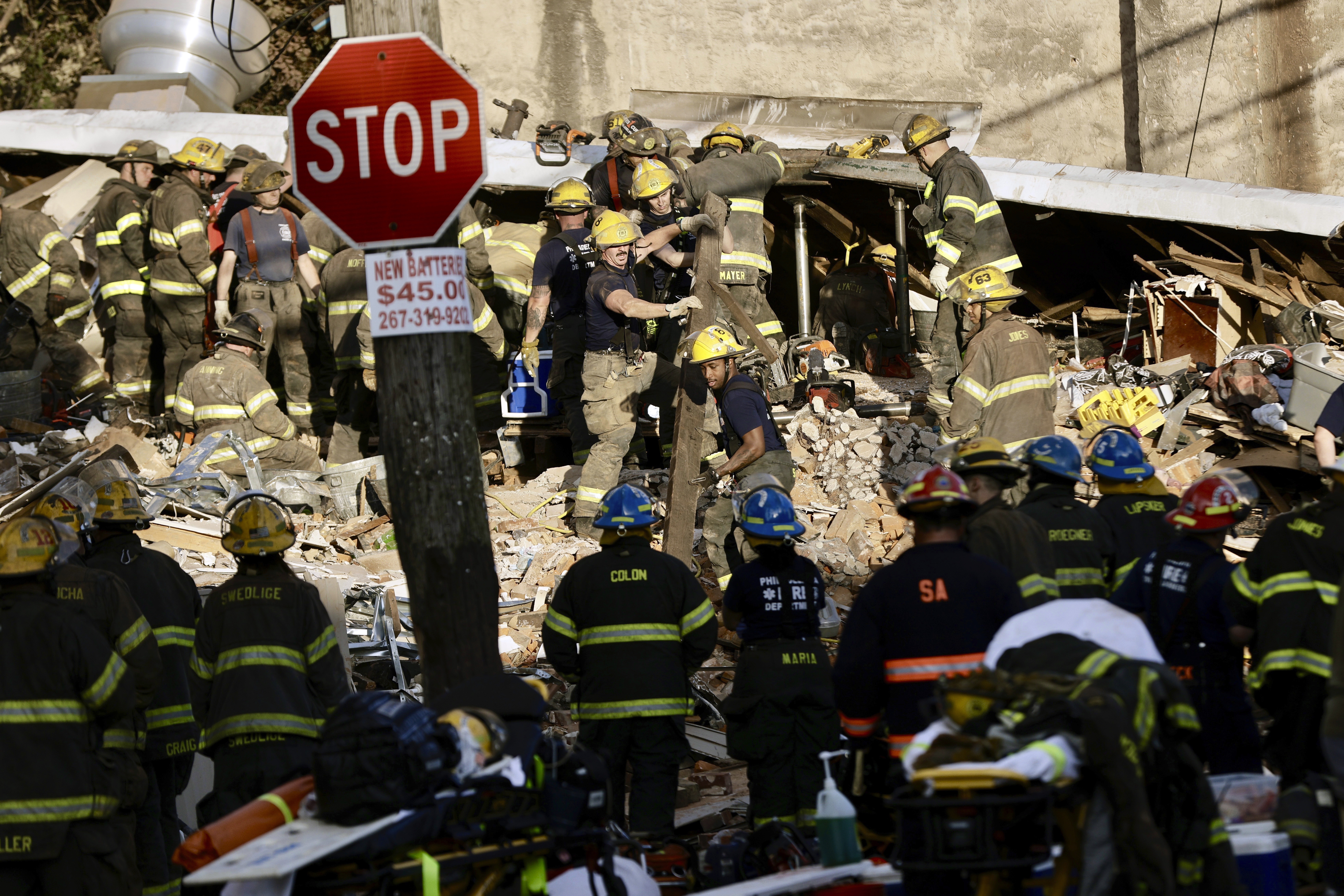 FILE - Philadelphia firefighters work to rescue colleagues trapped in a row house collapse on the 3...